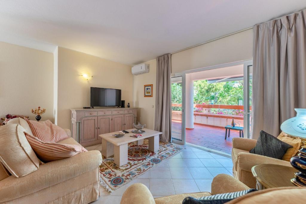 een woonkamer met een bank en een tv bij 2 BDR W/Balcony in Vale do Lobo by LovelyStay in Almancil