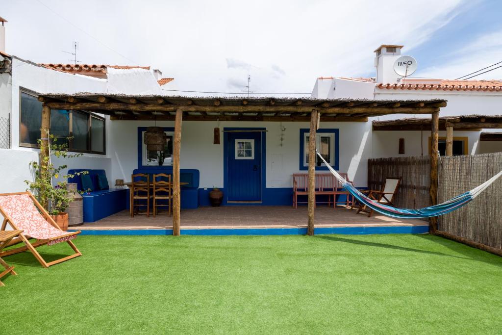 a patio with a hammock in front of a house at Sunrise Monsaraz Blue - Casa com 2 quartos Jardim in Monsaraz