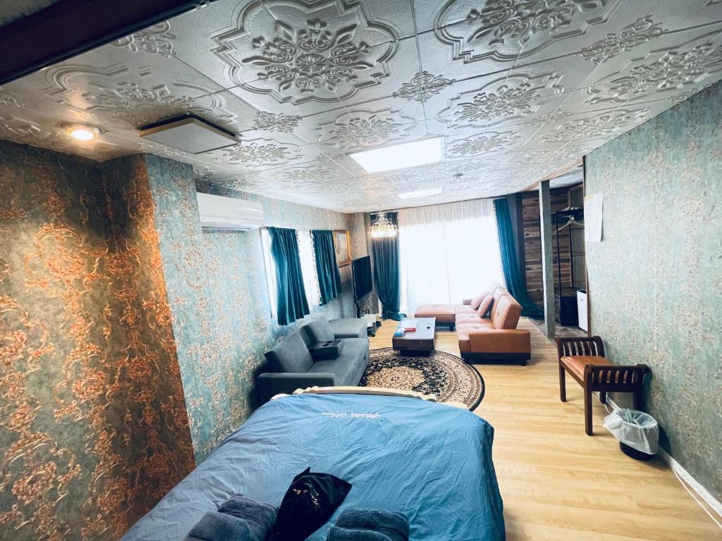 1 dormitorio con 1 cama y sala de estar en Ryokan La Luna, en Izu