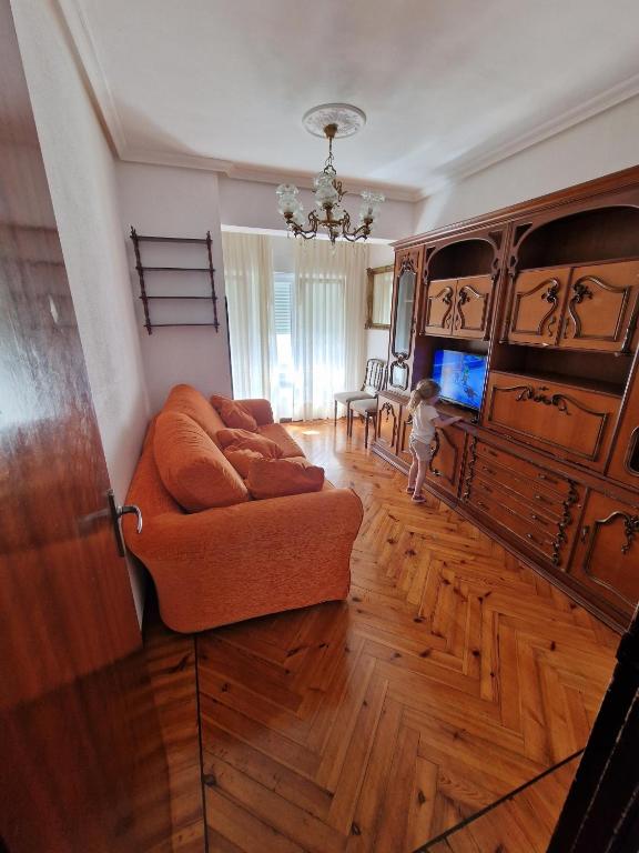 a child standing in a living room with a couch at APARTAMENTO SUJARRERA in Villacarriedo