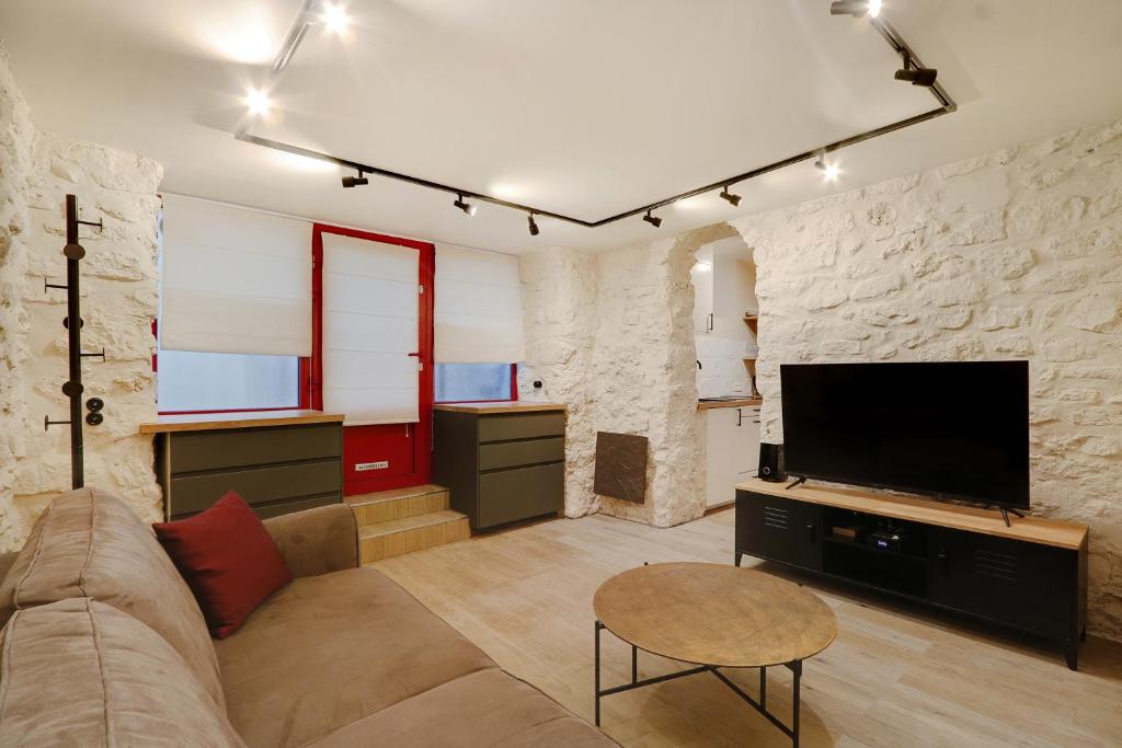 a living room with a couch and a flat screen tv at Pick A Flat's Apartment in Montmartre - Rue Drevet in Paris