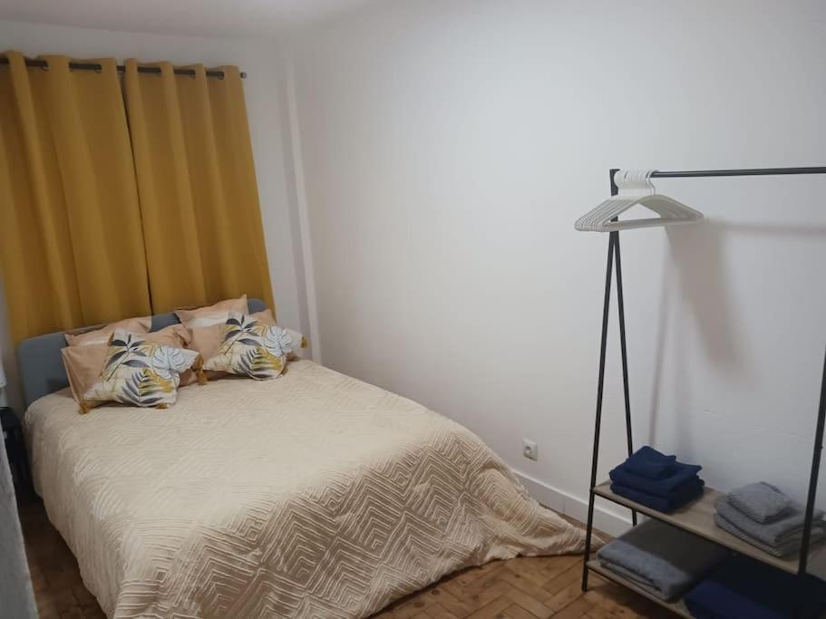 um quarto com uma cama e um candeeiro em Simpático apartamento no centro em Lisboa
