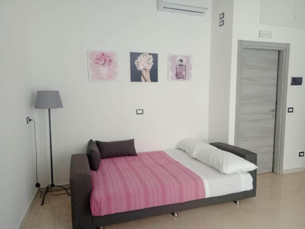 a bedroom with a bed with a pink and white blanket at L'atelier - Locazione turistica in Scilla