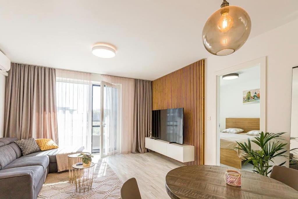 een woonkamer met een bank en een tafel bij Urban apartment with free parking in Bratislava