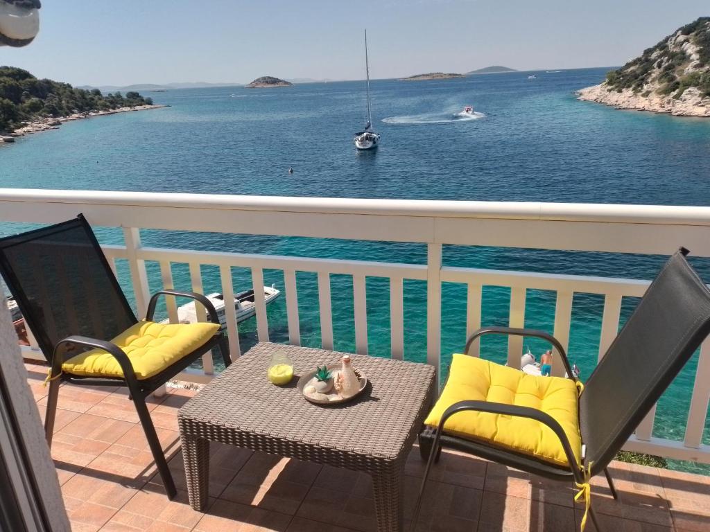 balkon ze stołem i krzesłami oraz oceanem w obiekcie Apartments Uvala Murtar w mieście Jezera