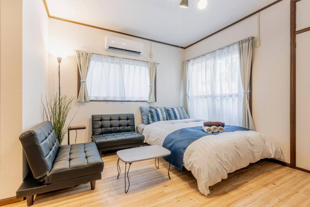 a bedroom with a bed and a couch and a chair at 渋谷まで電車で1駅 2分池尻大橋駅まで徒歩8分民泊アパート in Tokyo