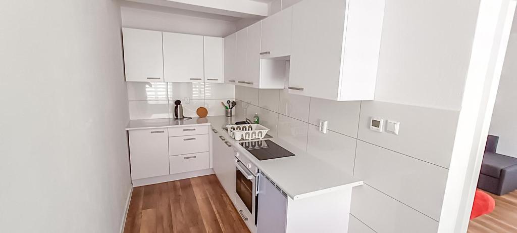 cocina blanca con armarios blancos y suelo de madera en Apartment 4 in Altstadt in Angermünde, en Angermünde