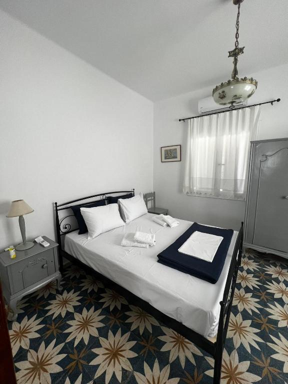 a bedroom with a large bed with a blue blanket at Elaia House-Eλαία in Spetses