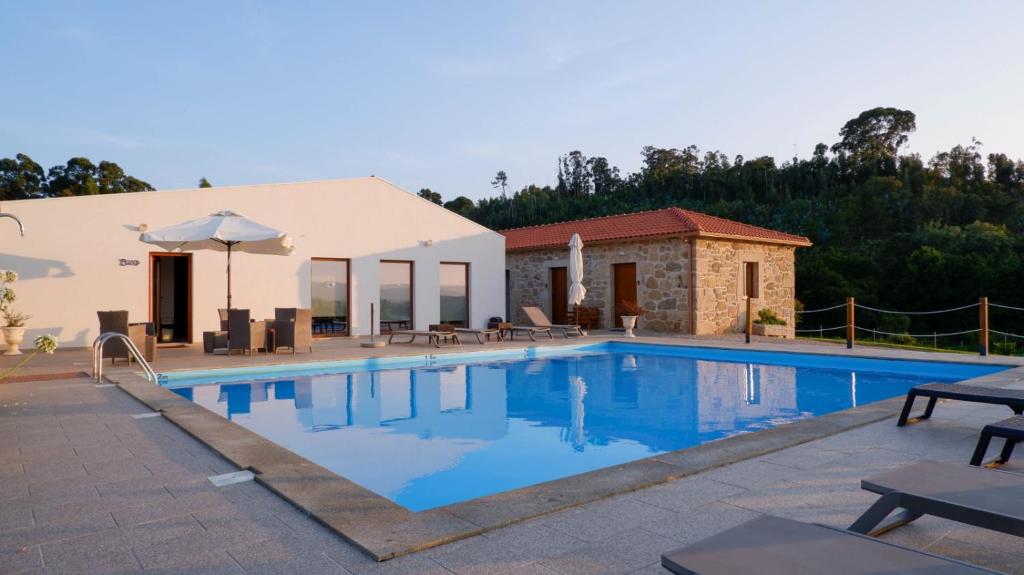 eine Villa mit einem Pool und einem Gebäude in der Unterkunft Quinta de Real in Valença