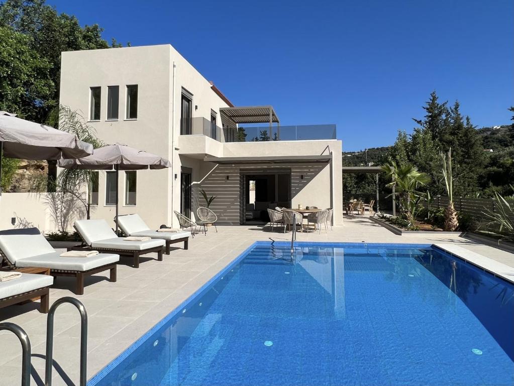 a villa with a swimming pool in front of a house at Villa Karissa in Gavalochori