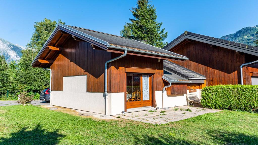 a small house with a garage in a yard at 35 CHALET - Chalet lumineux 6 pers in Morillon