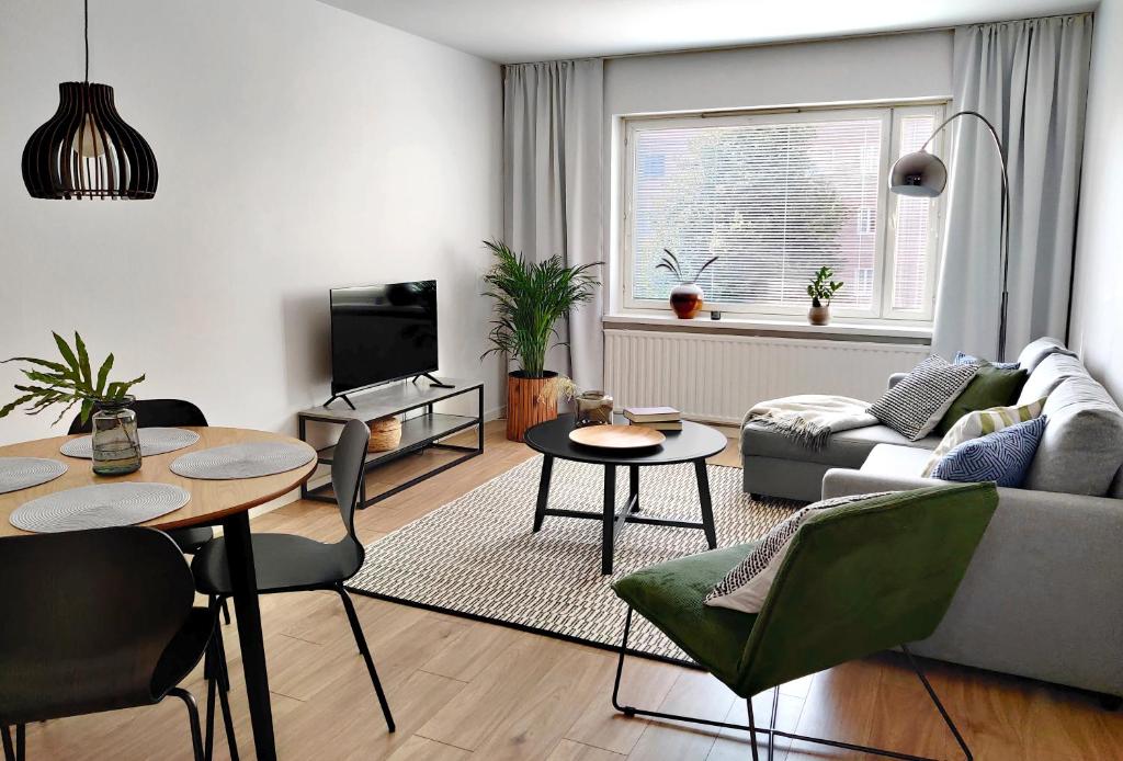 Trendy apartment in the heart of green Lahti, free parking في لاهتي: غرفة معيشة مع أريكة وطاولة