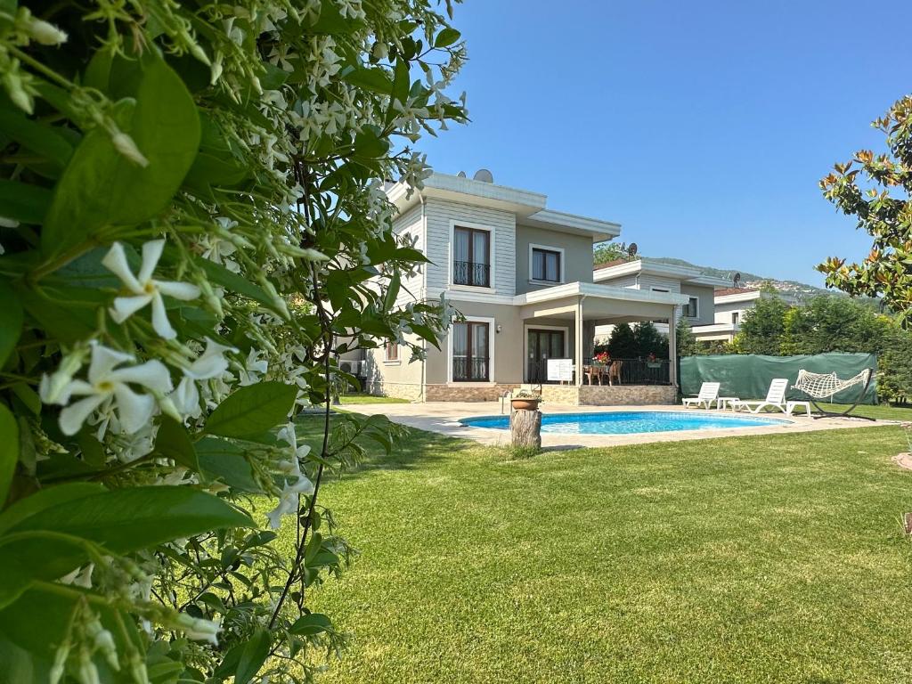 una casa con un patio con piscina en Guzel Evler Family Resort en Sapanca