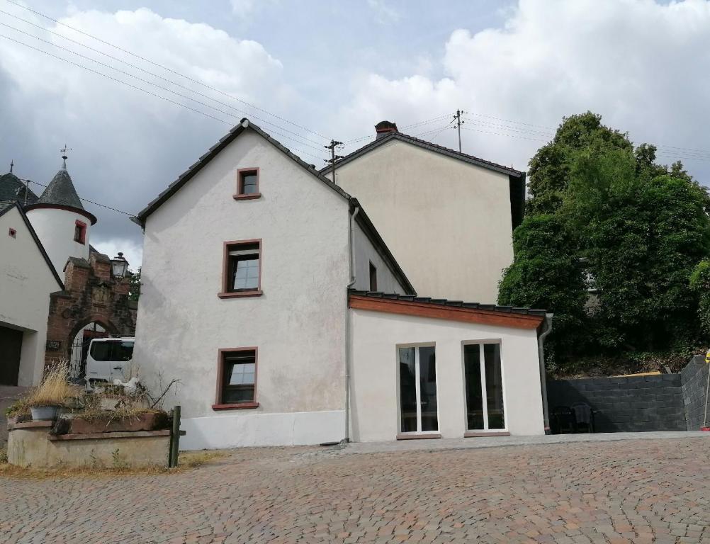 una casa blanca con una iglesia en el fondo en Ferienhaus Alte Münze en Neuerburg