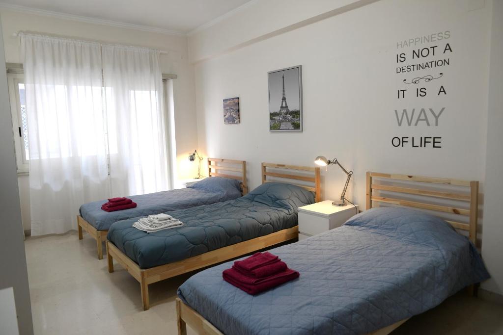 a bedroom with three beds with blue sheets at Room in Guest room - Emilios home Triple room in our cozy and comfortable establishment in Rome