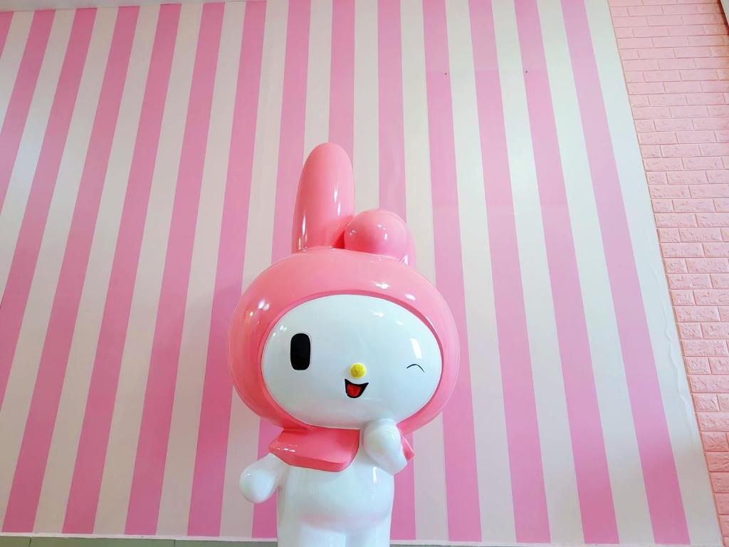 Un lapin jouet est debout à côté d'un mur rose dans l'établissement Puchong HELLO KITTY FULLY AIR-CON Suite, à Puchong