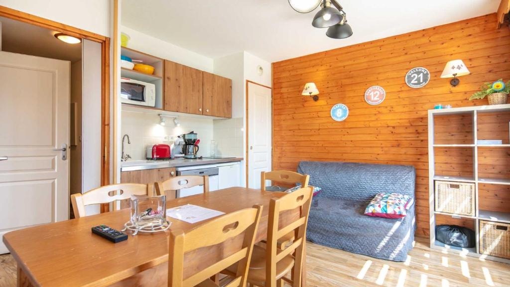 a kitchen and dining room with a table and a couch at V DU BACHAT - Silene D11 in Chamrousse
