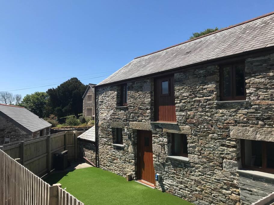 a stone house with a green lawn in front of it at Piglets. Spacious, Modern, Peaceful, nr Port Isaac in Camelford