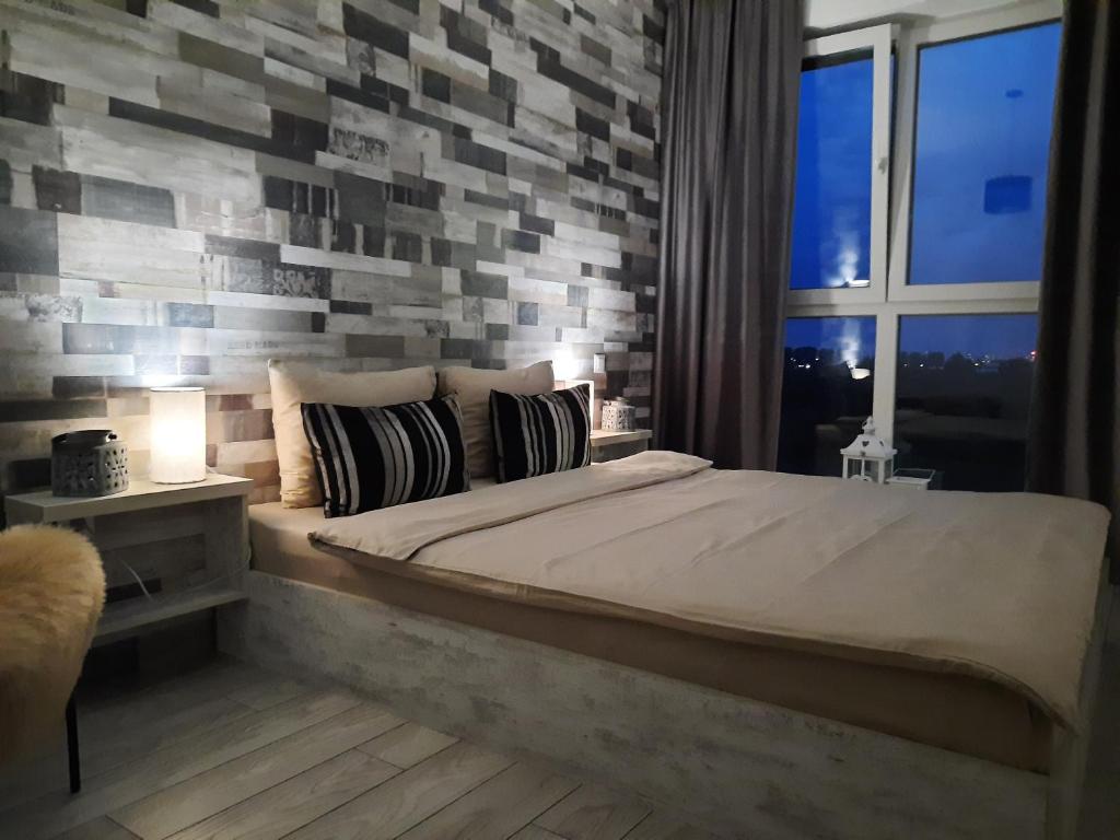 ein Schlafzimmer mit einem großen Bett mit Ziegelwand in der Unterkunft Grey Residence Apartament in Târgu Mureș