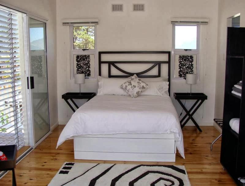 a bedroom with a white bed and two windows at ZEN Tree bed & breakfast in Paarl