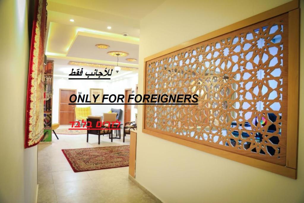 a lobby with a door with a sign that reads only for foreigners at Eco Hostel in Ramallah