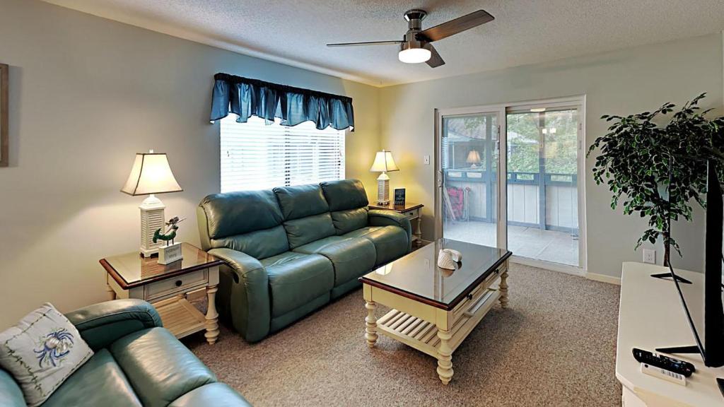 uma sala de estar com um sofá e uma mesa em Experience Tranquility at Summertree Village Condo em Myrtle Beach