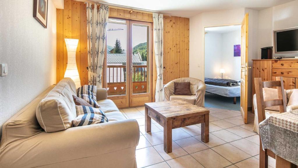 ein Wohnzimmer mit einem Sofa und einem Tisch in der Unterkunft Dome de la cochette - 8 - Appart 6 pers in Saint-Sorlin-dʼArves