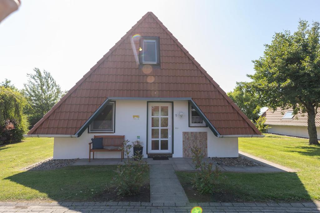 a small white house with a brown roof at HA 9 - Strandvogt 3 Komfort in Schottwarden