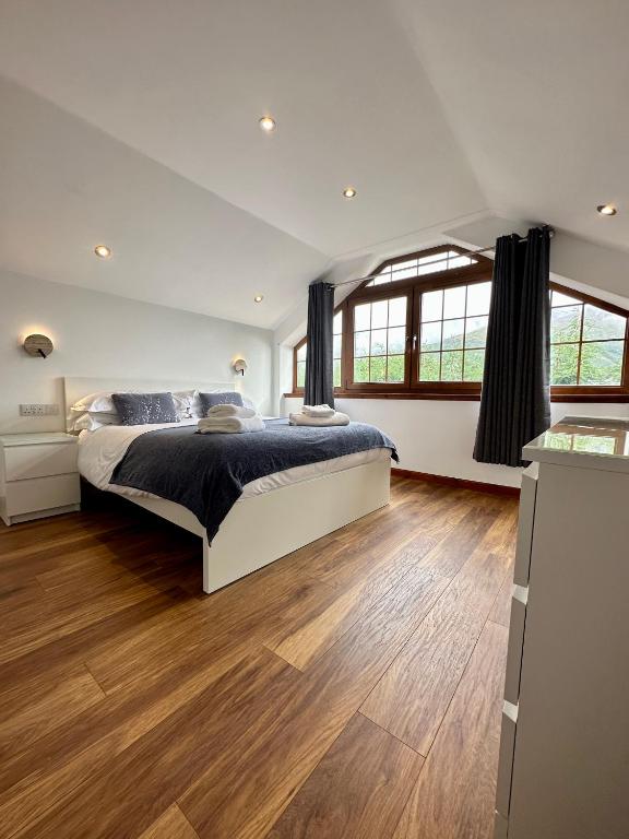 um quarto com uma cama grande e pisos em madeira em 2 Sheraton Apartments em Fort William