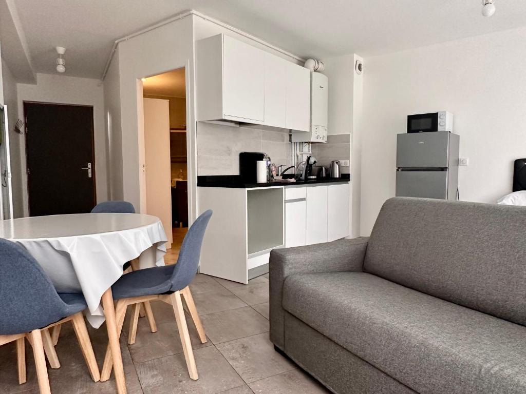 a living room with a couch and a table at Residence 4T - 33 Avenue Gaston Chauvin in Aulnay-sous-Bois