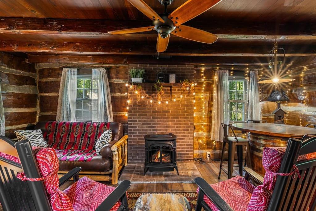 a living room with a couch and a fireplace at Boozy Bear Bungalow romantic cabin 5 mins 2 downtown with hot tub and fire pit in Gatlinburg