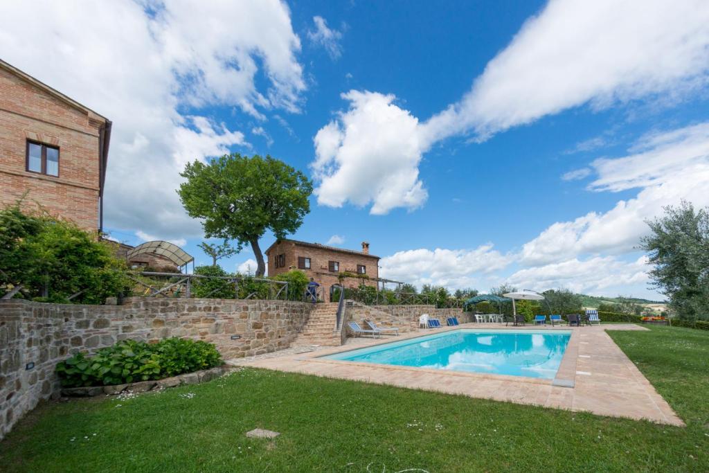 una casa con piscina en un patio en Villa Serena - Homelike Villas en SantʼAngelo in Pontano