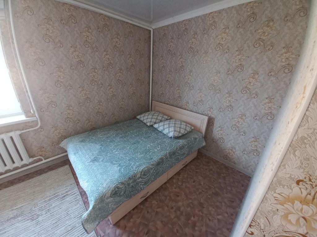 a small bed in a corner of a room at Hotel "Тихий Дом Трансфер" in Bishkek