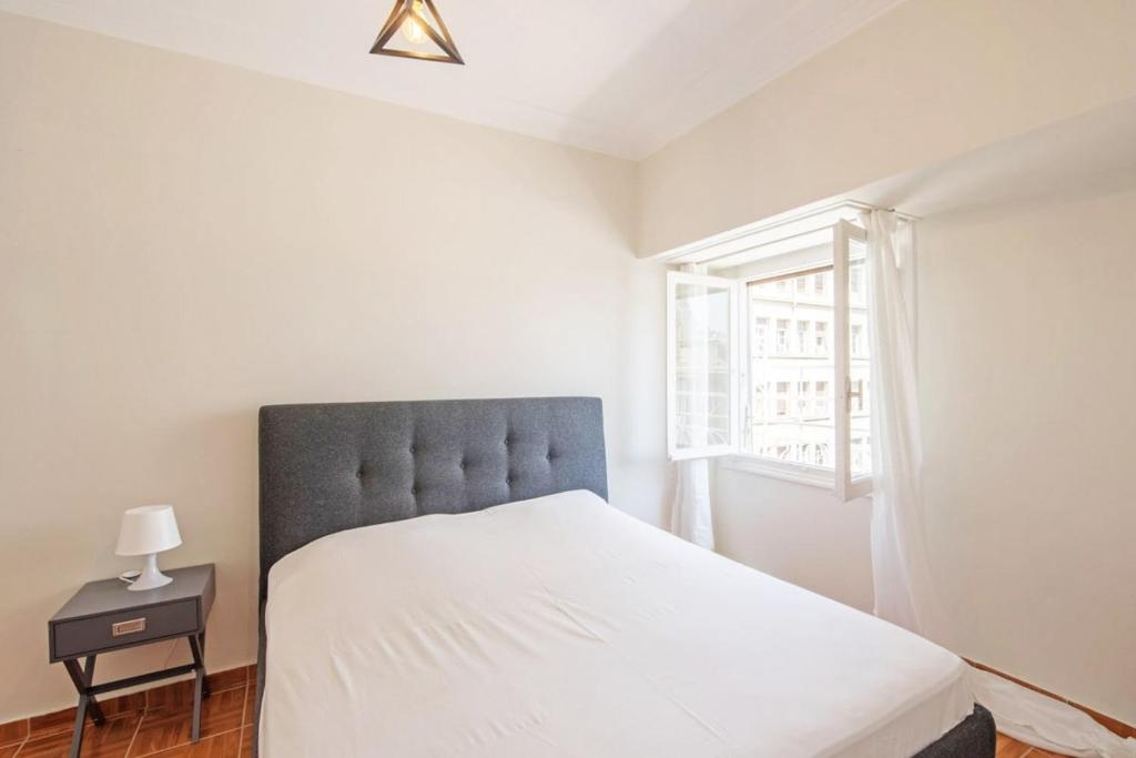 a bedroom with a large bed and a window at Spacious 3 bedroom apt in Eksarchia in Athens