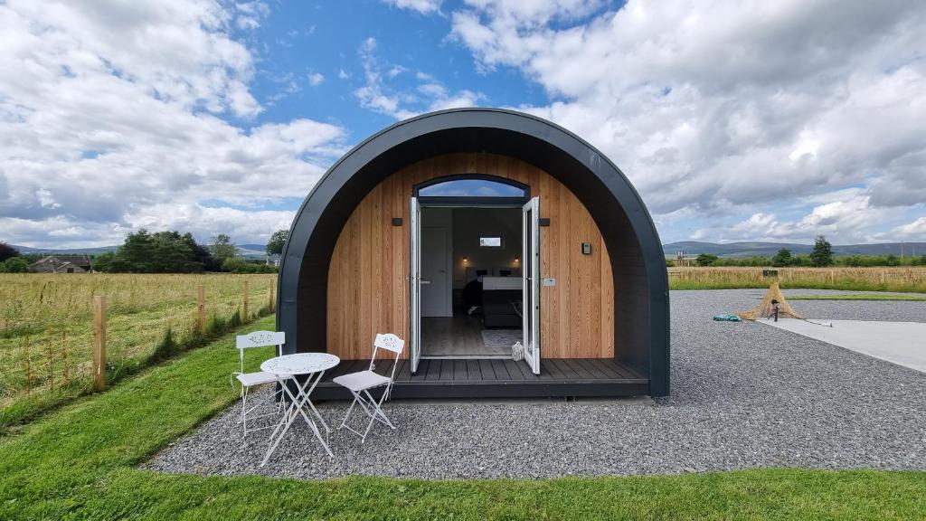 a small circular house with a table and chairs at Bombie Glamping Pod in Grantown on Spey