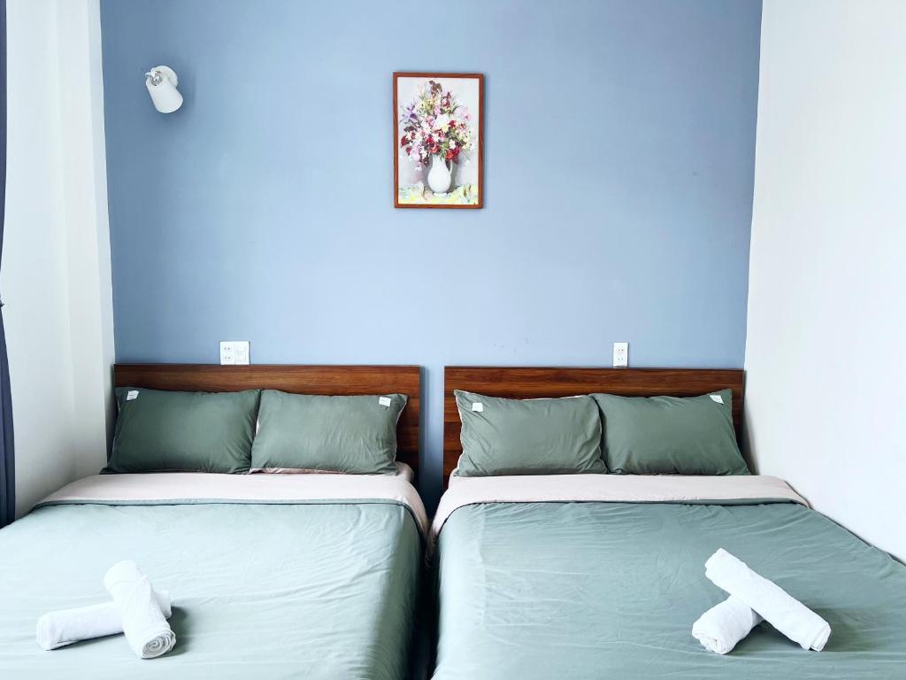 twee bedden naast elkaar in een kamer bij Pema House Hotel in Da Thanh