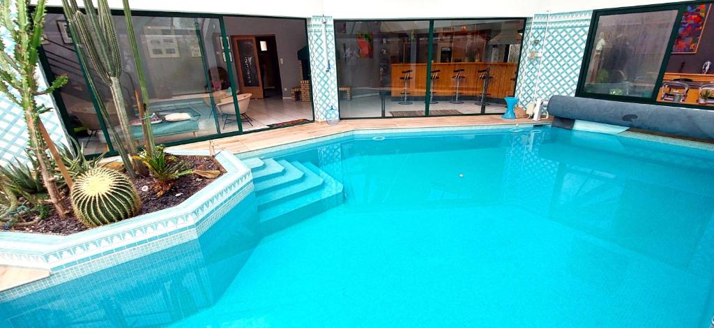 加來的住宿－Villa Margrit, escapade en bord de mer et détente dans la piscine chauffée，一个带仙人掌的大型蓝色游泳池