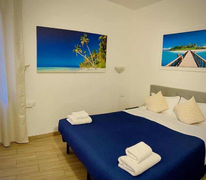 una camera da letto con un letto blu e asciugamani di CASA BANON a Venezia