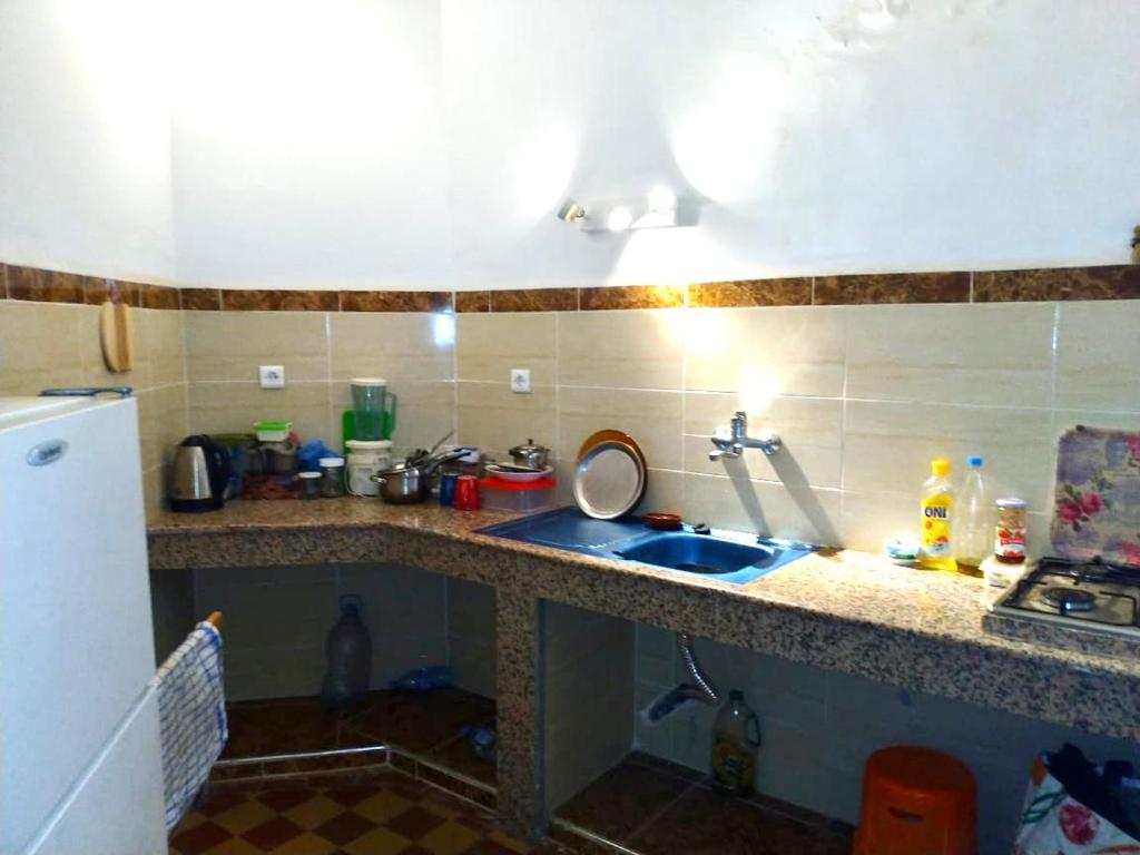 um balcão de cozinha com um lavatório e um frigorífico em Chez abdessalam em Fez