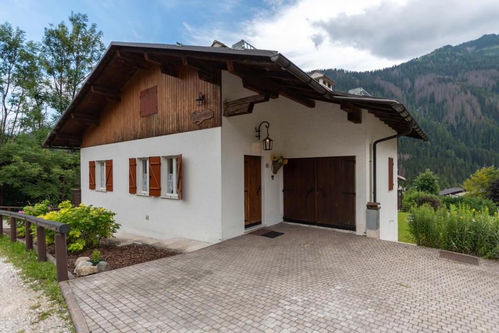 a small white house with a driveway at Villa Elisena in Falcade