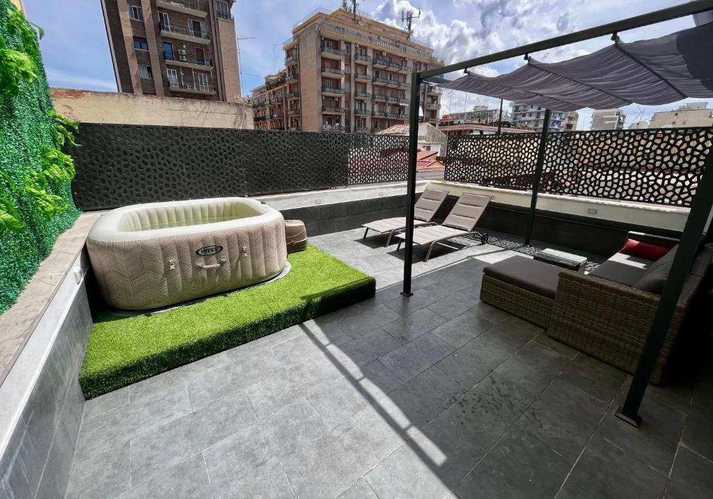 un patio en la azotea con césped verde y un sofá en Residence Terrazza Perez - appartamento indipendente, en Foggia