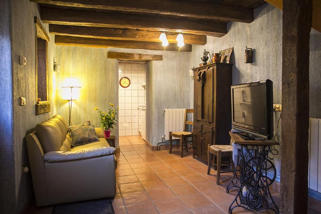 a living room with a couch and a tv at Casa rural Txikirrin Txiki - Selva de Irati in Villanueva de Aézcoa