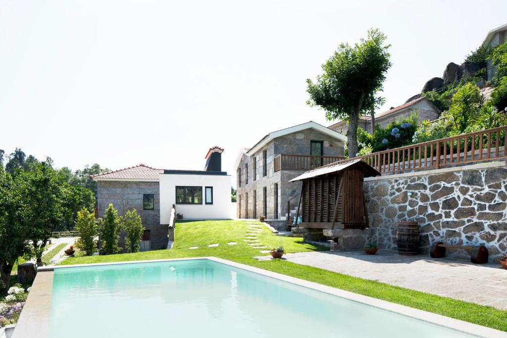 a swimming pool in front of a house at CASA DAS FONTELAS in Castelo de Paiva