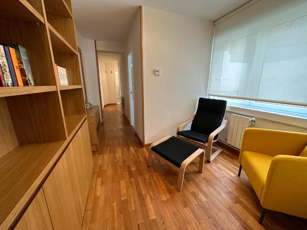 sala de estar con 2 sillas y ventana en Oktheway Praza de España en A Coruña