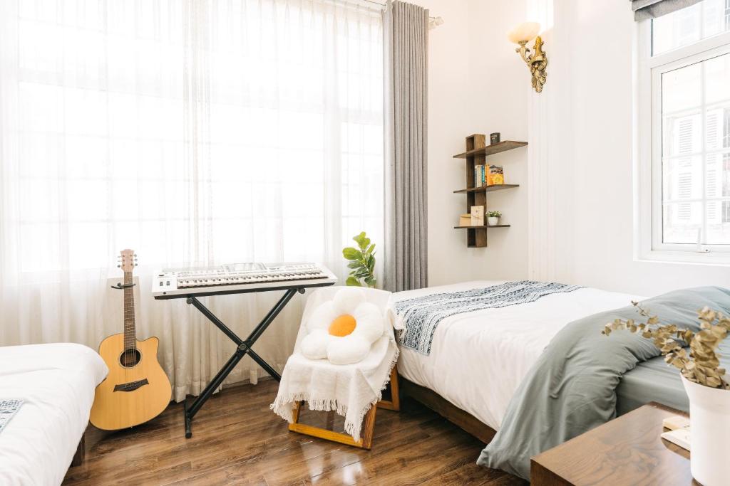 1 dormitorio con guitarra y escritorio con teclado en An Family Homestay, en Hanói