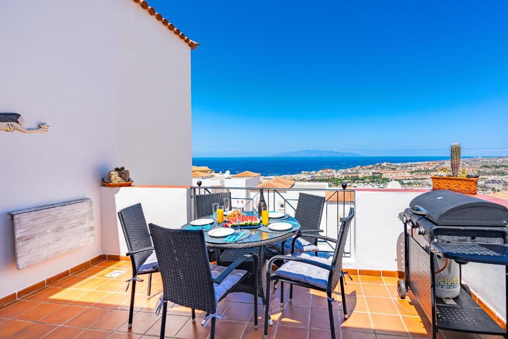 d'une salle à manger avec une table et des chaises sur un balcon. dans l'établissement BuenaVista Bellarosa Sunset Ocean View in Costa Adeje with airco, garage, à Adeje