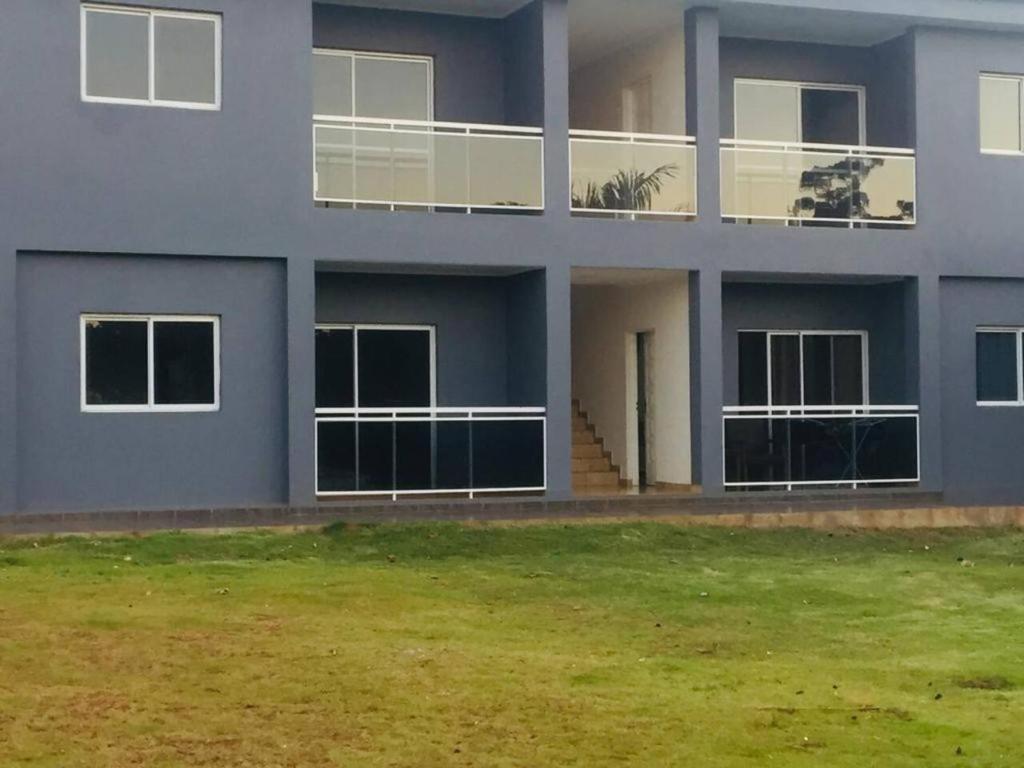 a blue building with a grass yard in front of it at Departamento Confortable in Puerto Iguazú