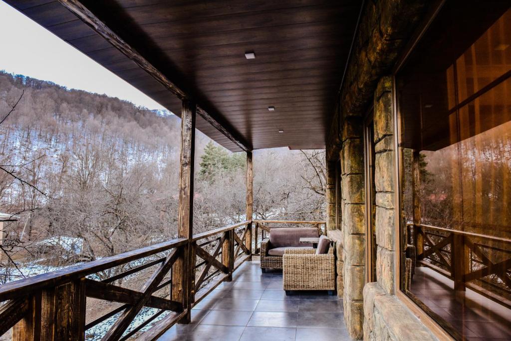 a room with a balcony with a view of the mountains at Maestro Rest House Dilijan in Dilijan
