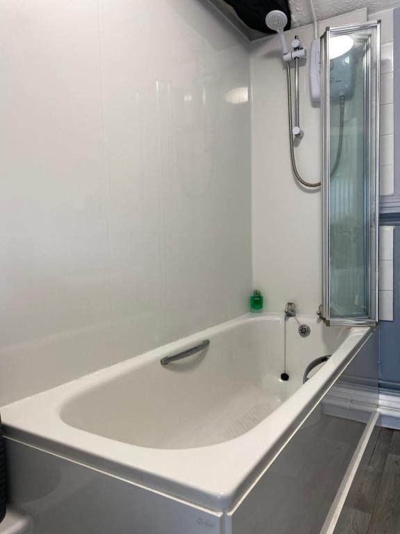 a white bath tub in a bathroom with a shower at The White Horse Crostwick in Norwich