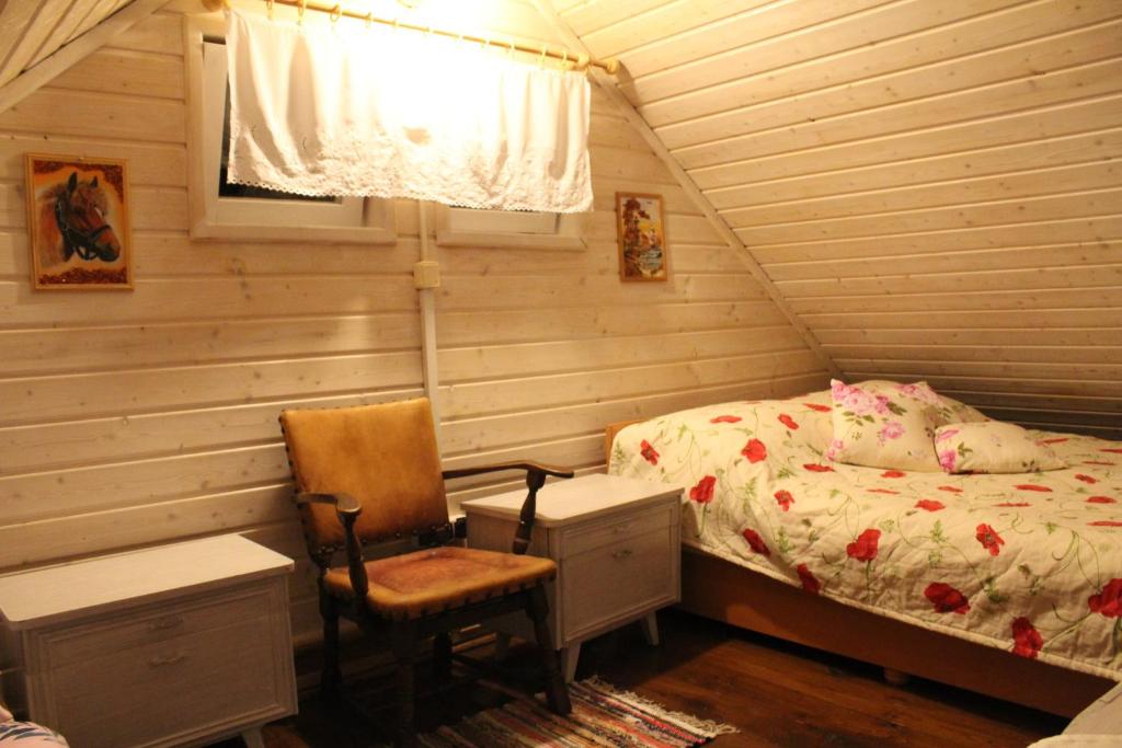 a bedroom with a bed and a chair and a desk at Niezapominajka in Bystrzyca Kłodzka